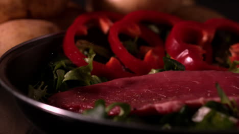 steak falling on bed of lettuce with red pepper