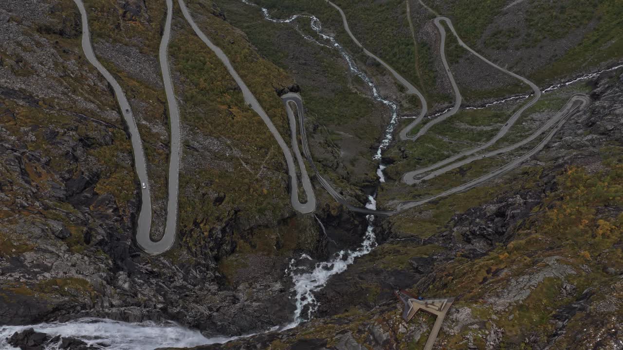 Drone view of sharp mountain bends at Trollstigen with moving cars