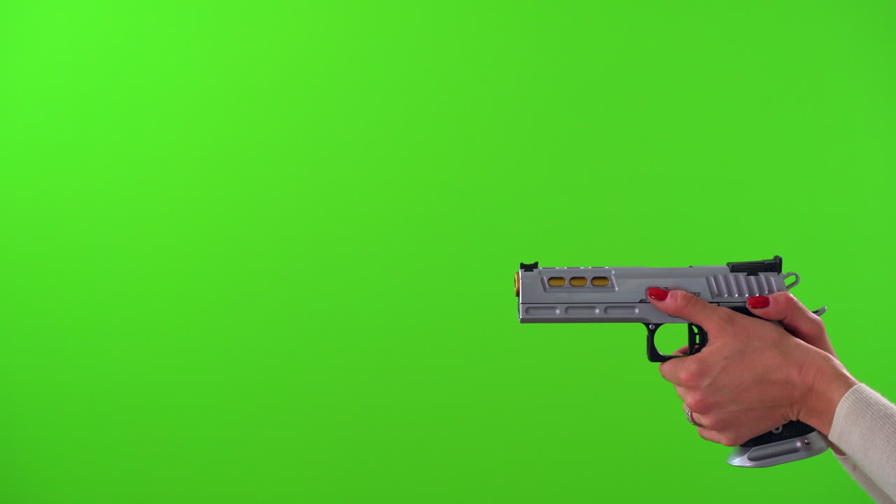 Woman aiming large silver handgun on green screen background