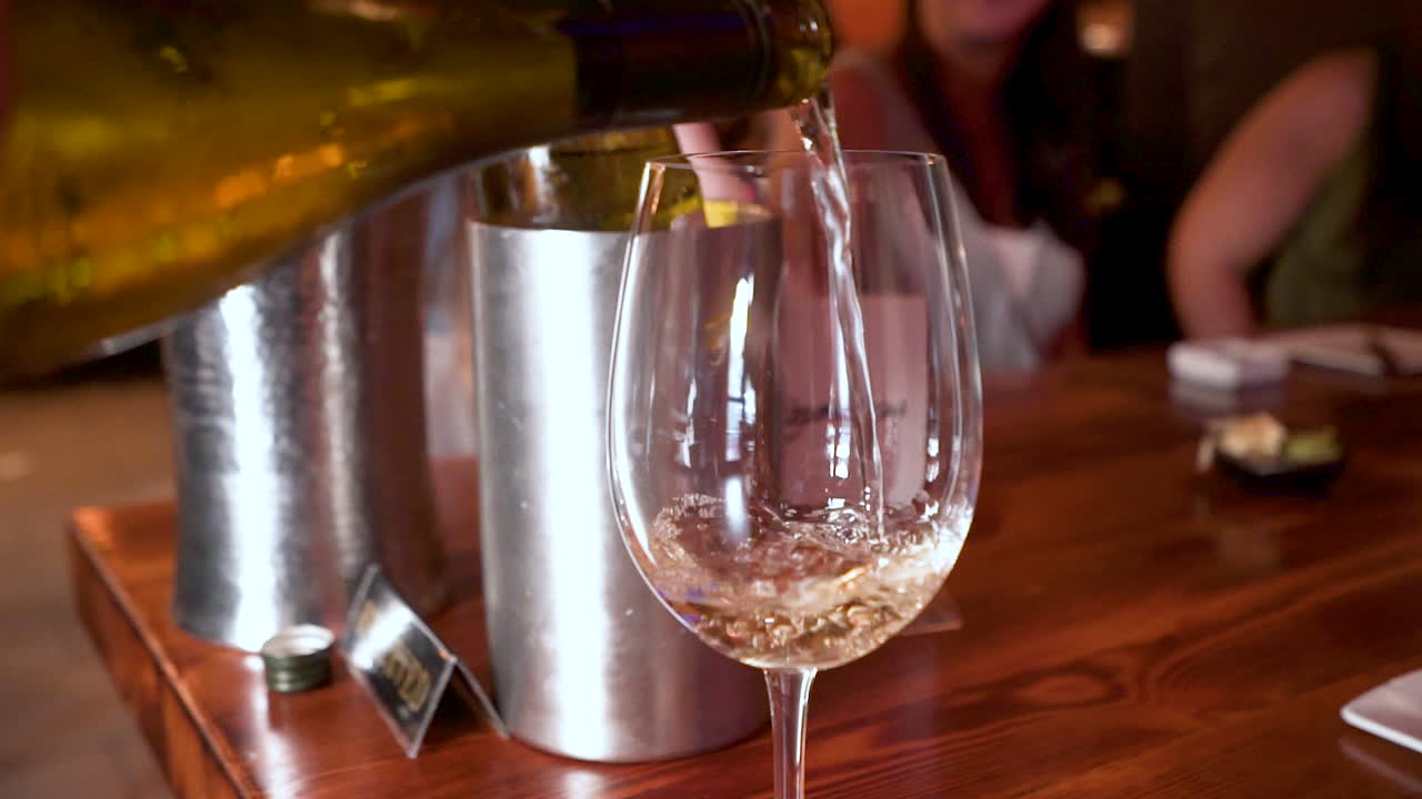 Vino bianco versato in un calice da vino a cena, HD.