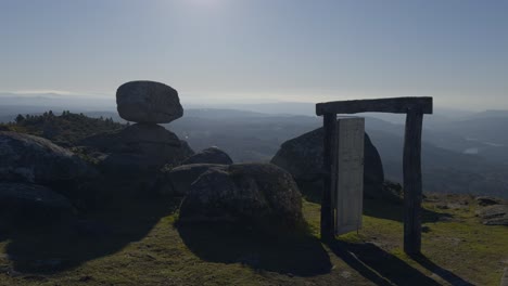 grandes vistas a la cima de una montaña con una puerta vieja y grandes rocas con sol