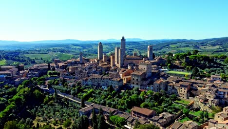 backward drone shot of the town of san gimignano, tuscany, italy with its famous medieval tower