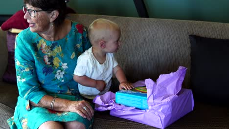 Grandma-and-grandson-opening-christmas-presents-on-sofa