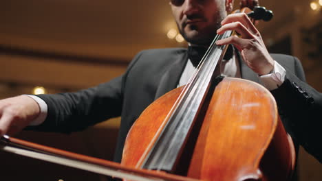 violoncellist is playing classic music on cello in modern music hall concert or rehearsal