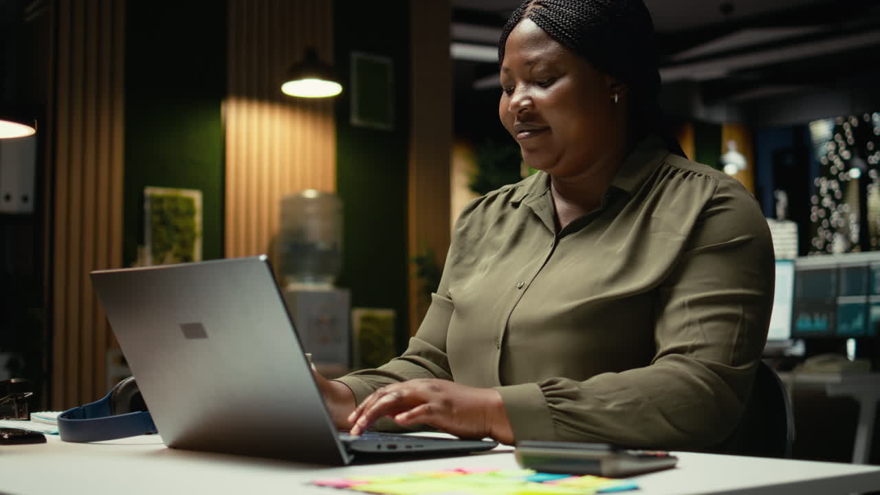 Black businesswoman typing data reports and managing information