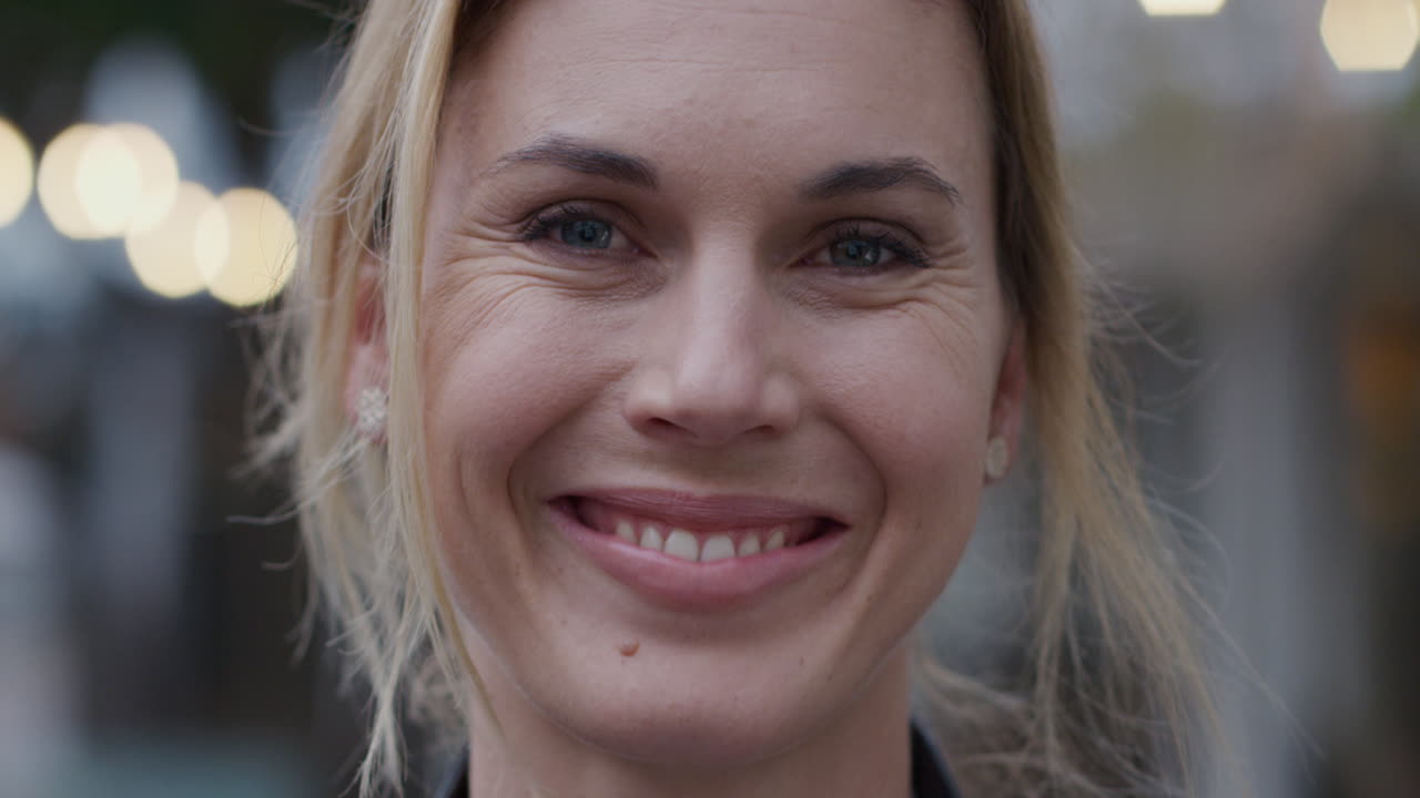 retrato de una hermosa mujer sonriendo al aire libre en la ciudad por la noche