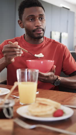 vertical video of happy african american couple having breakfast at home in slow motion