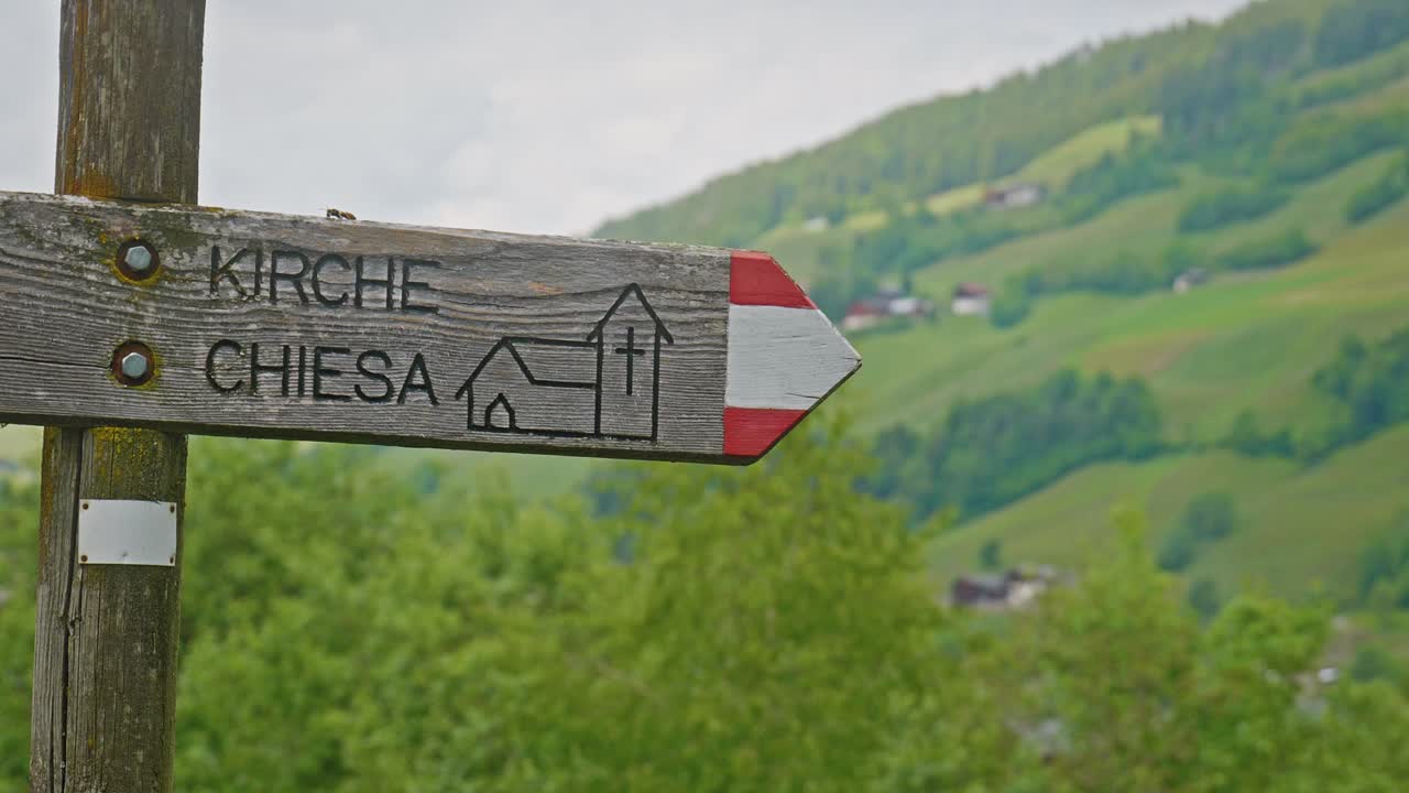 Wooden Hiking trail Sign post direction to local South Tyrol church