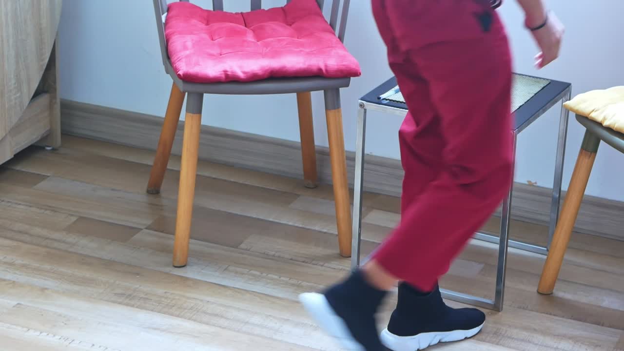 Young asian student dressed in uniform carefully puts on shoes before school day begins