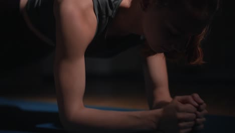 Young woman exercises arms with commandos on the floor, slow motion