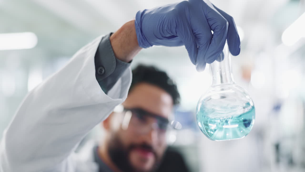 Scientist holding a flask with blue liquid