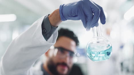 scientist holding a flask with blue liquid