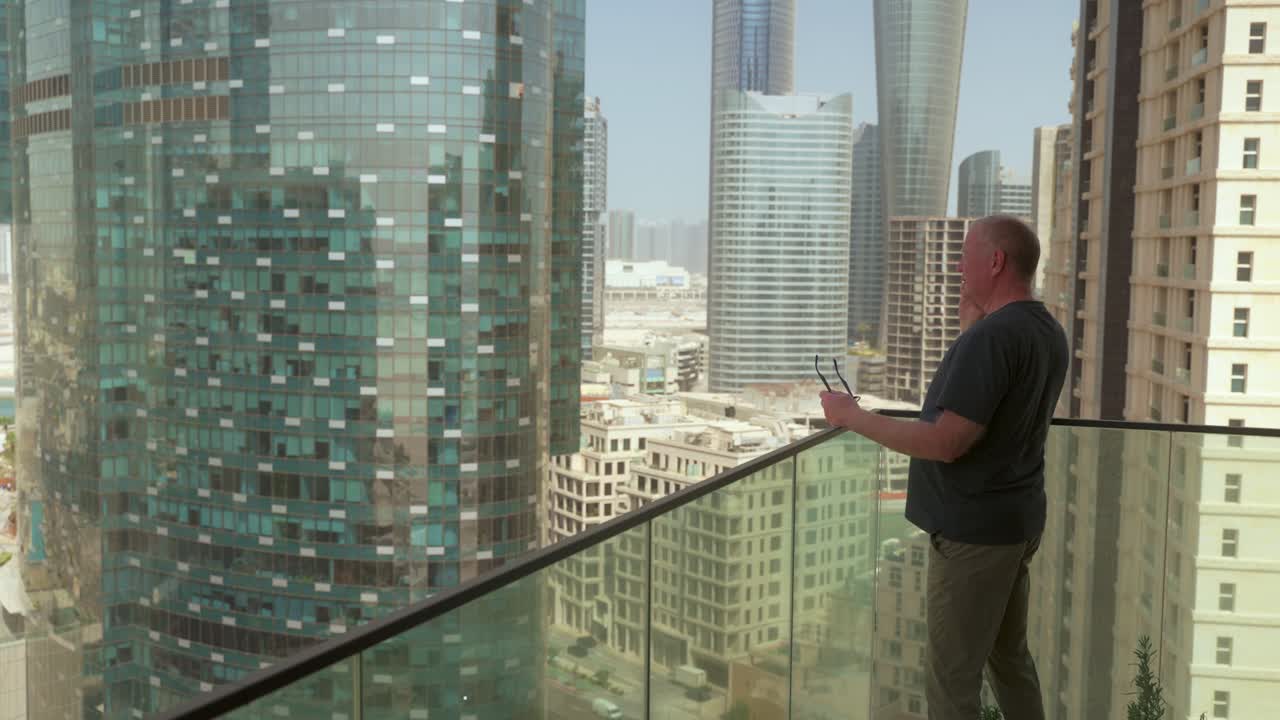 Senior man living in a big city on an important mobile smartphone call is frustrated then hangs up to consider the information received - skyscrapers in the background