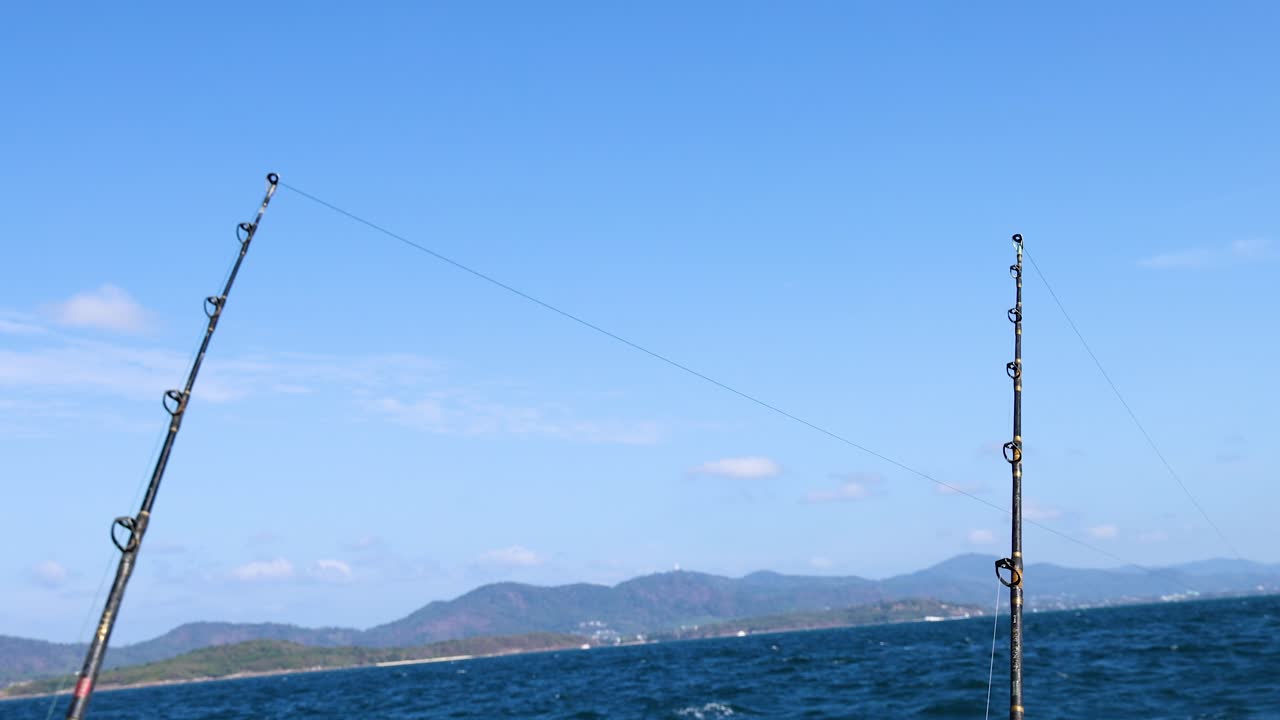 A serene fishing scene on a boat in Phuket, Thailand, with clear skies and gentle waves