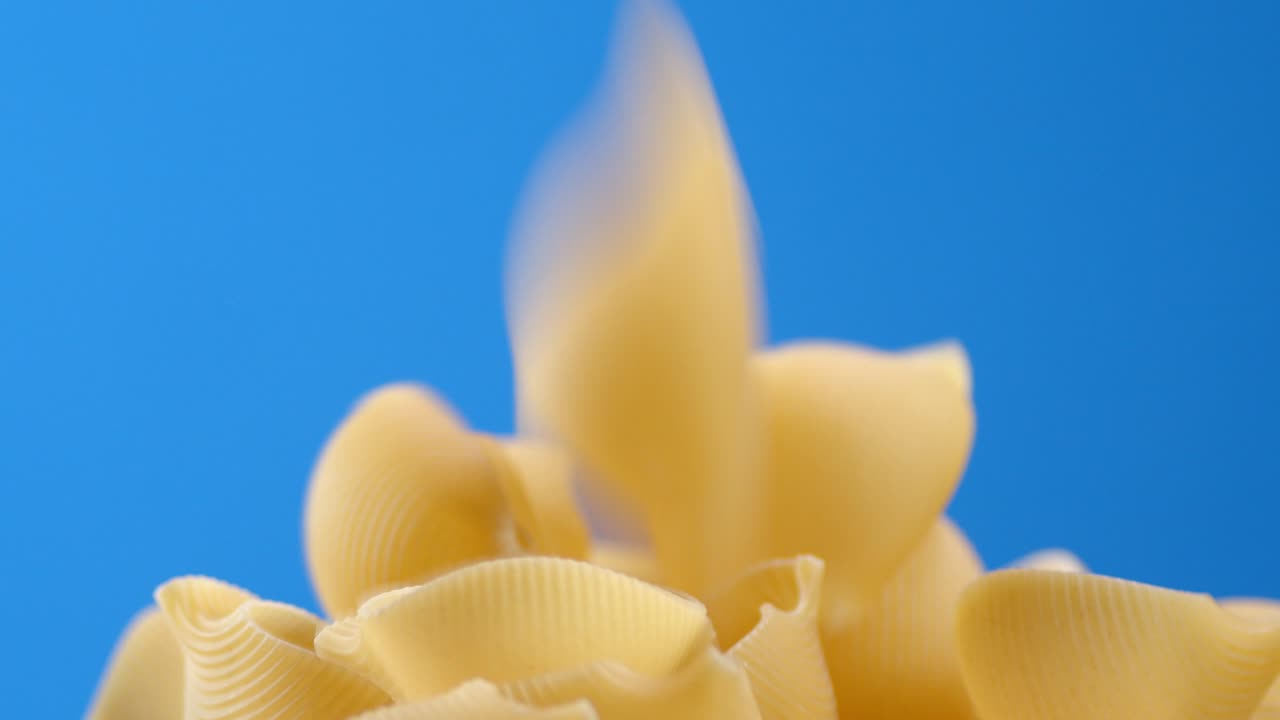 la pasta seca cae en la mesa en un montón.