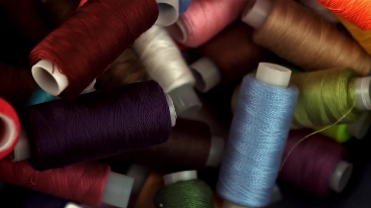 Colorful Spools of Thread Falling and Settling