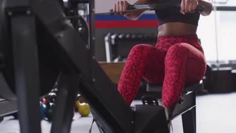 Video-Einer-Entschlossenen-Afroamerikanischen-Frau,-Die-Im-Fitnessstudio-Ein-Rudergerät-Benutzt