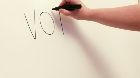 Hand-writing-the-word-vote-and-an-arrow-on-a-sign