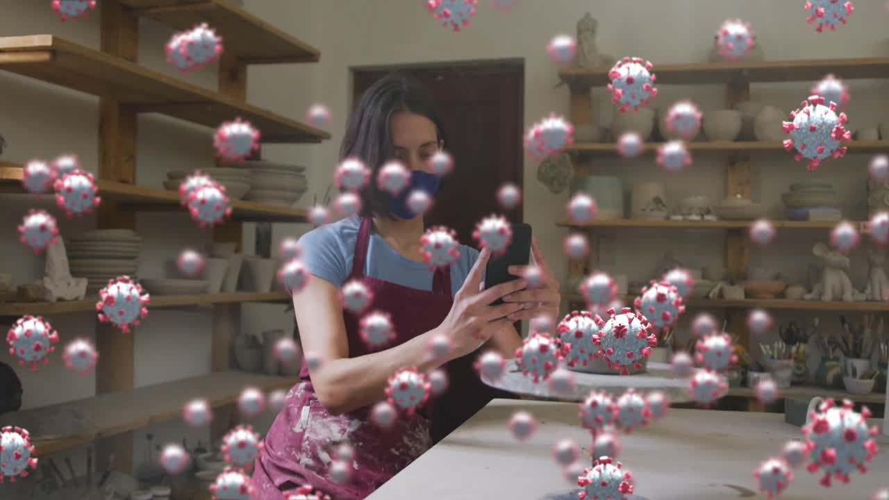 células de covid-19 flotando contra la alfarera caucásica femenina tomando una foto de la arcilla en la rueda del alfarero