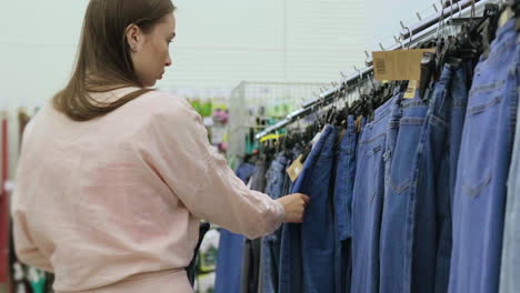 mujer comprando vaqueros en una tienda