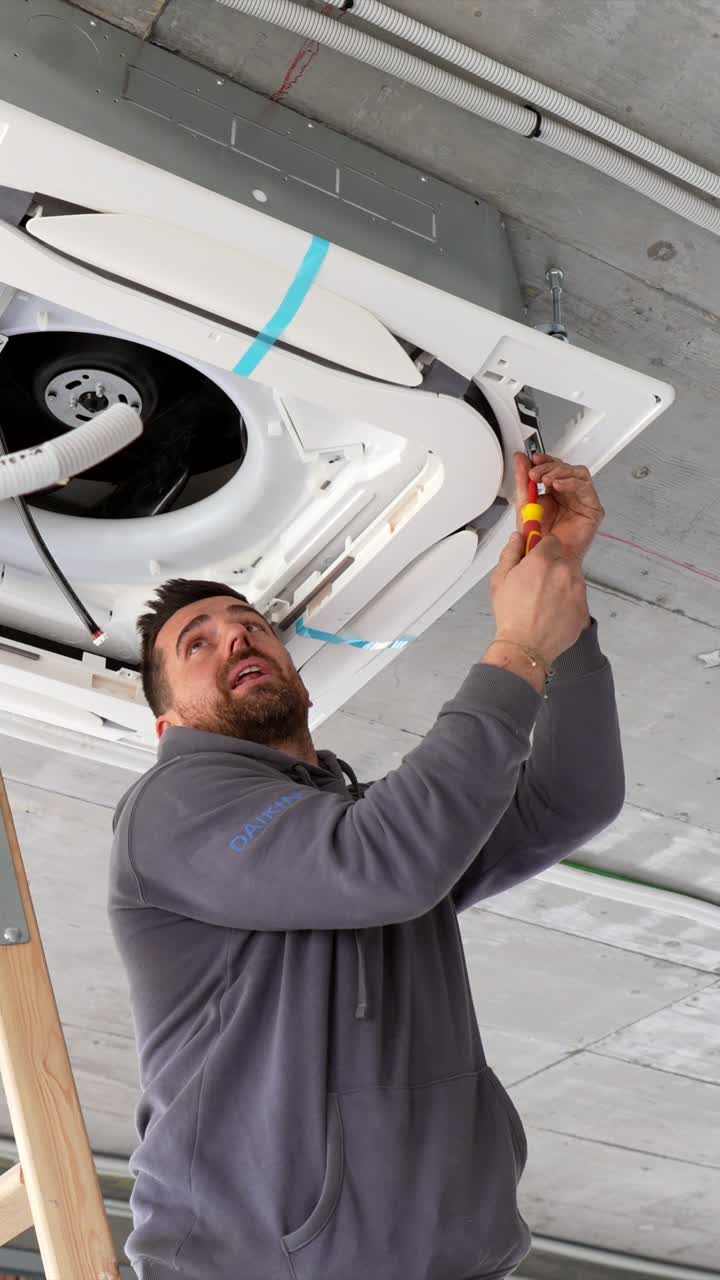 HVAC Technician Installing Ceiling Air Conditioning Unit