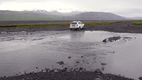 un todoterreno conduce a través de un río en las remotas tierras altas de islandia