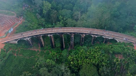 experience the enchanting beauty of ella, sri lanka with this breathtaking aerial drone footage capturing the iconic nine arches bridge on a misty day.