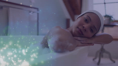 animation of light spots over african american woman taking bath