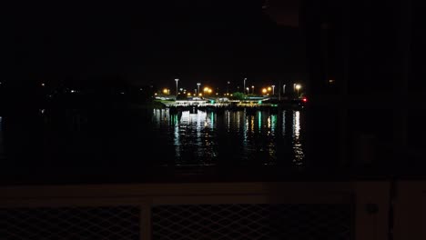 entering a port by boat to dock lit up at night