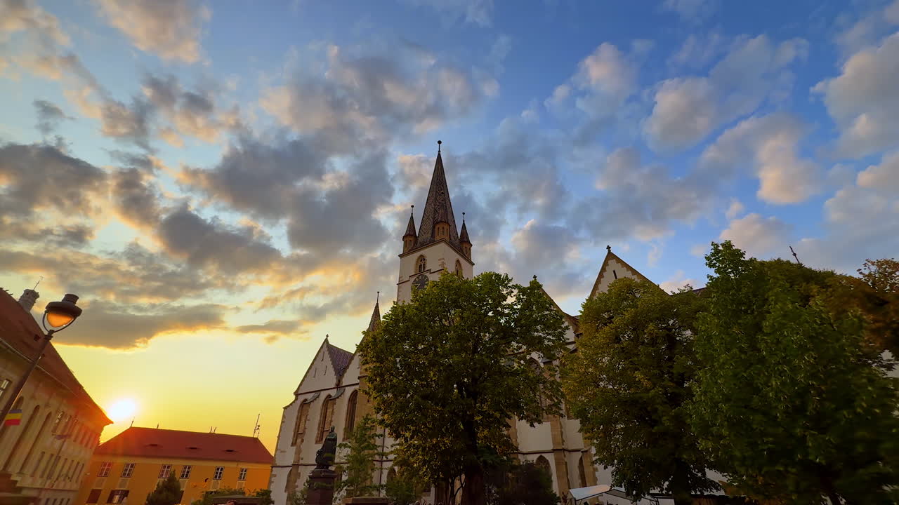 Sibiu, Romania, 17 luglio 2025: passeggiata per le strade di Sibiu, Romania, al tramonto. Visuale dal basso verso l'alto sulle guglie della cattedrale luterana di Santa Maria.