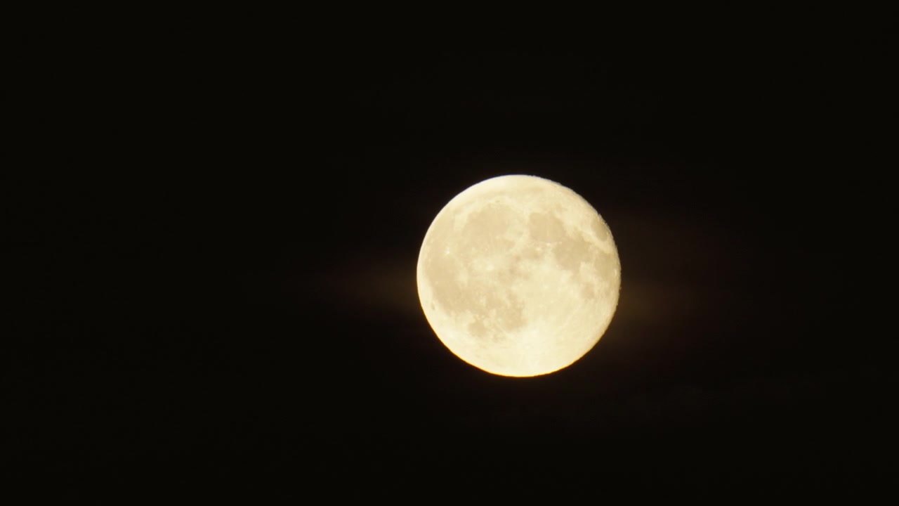 Plano médio da Lua com nuvens suaves passando enquanto o objeto celestial se move pela tela