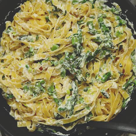 Tagliatelle-Nudeln-Mit-Ricotta-Käsesauce-Und-Spargel,-Serviert-Auf-Einer-Schwarzen-Eisenpfanne