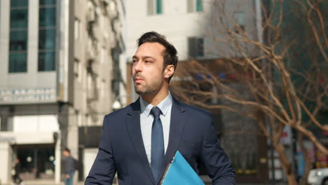 hombre de negocios satisfecho y exitoso comiendo una rosquilla al aire libre en una calle de la ciudad caminando con una carpeta con documentos, mirando a su alrededor con admiración en un día soleado