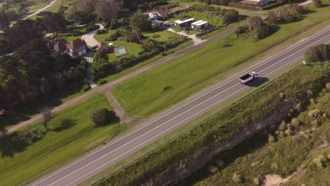 Aerial-view-of-industrial-white-truck-driving-on-rural-highway-road-near-Chapadmalal,Argentina