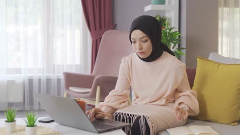 Estudiante-Joven-Musulmana-Trabajando-En-Una-Computadora-Portátil-En-Casa.