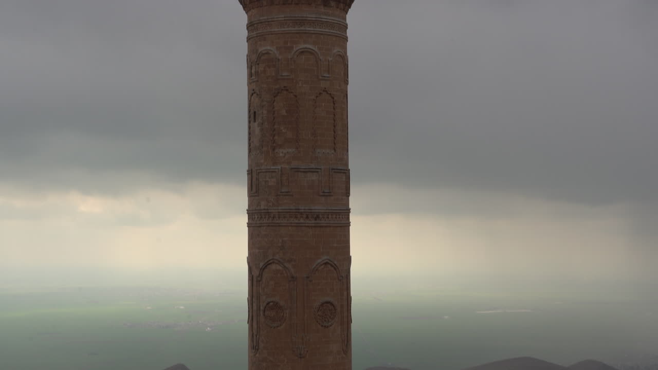 la cámara inclina el minarete histórico de la mezquita mardin ulu, hecho de piedra cortada, de arriba a abajo