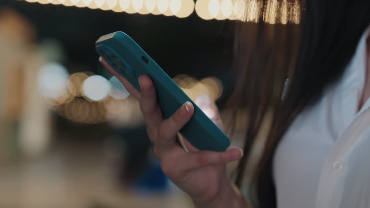 Woman using a phone outdoors at night