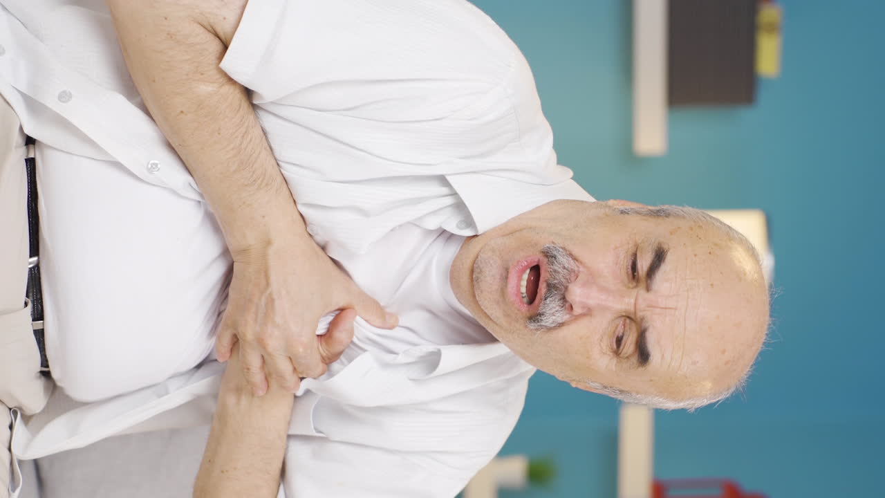 video vertical de un anciano con dolor en el pecho.