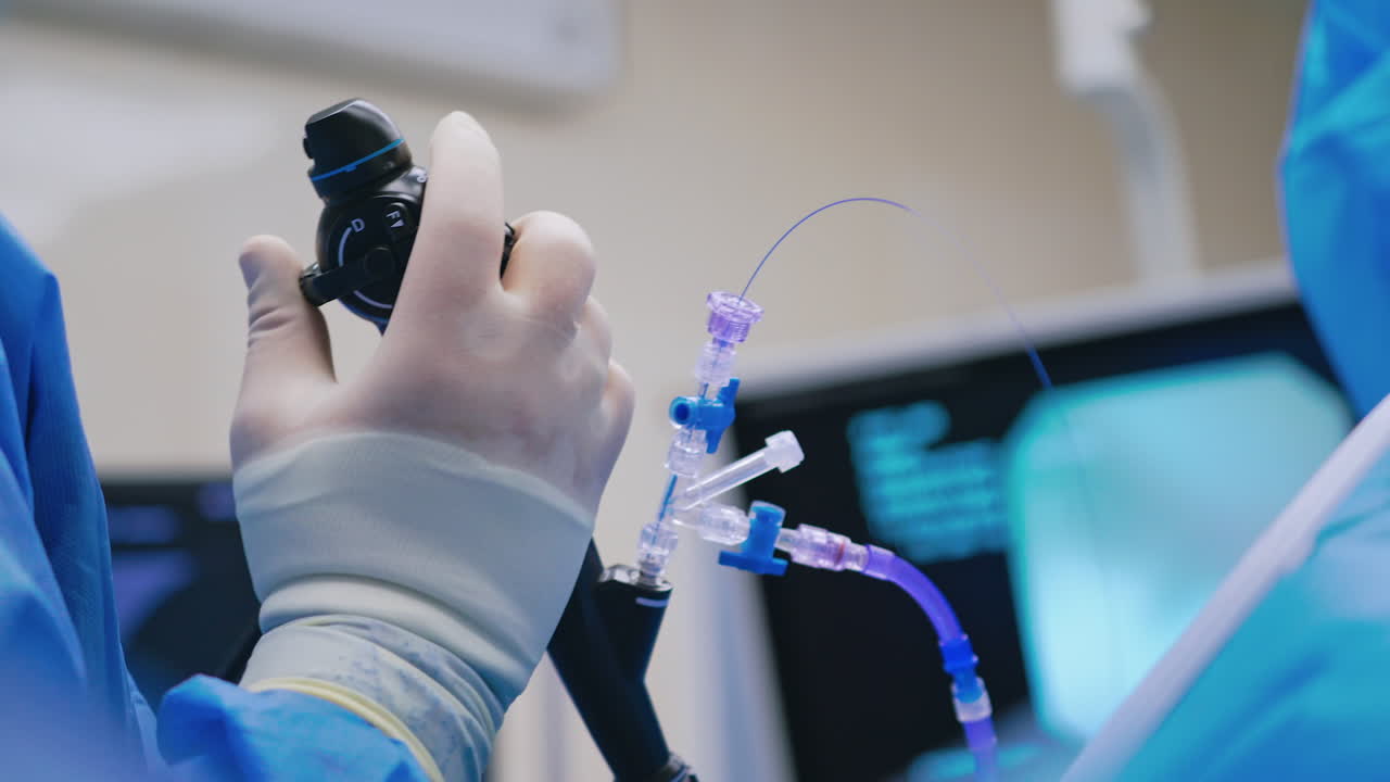 Endoscopic surgery. Surgeon's hand holds medical instrument on the blur background of a monitor. Close-up.