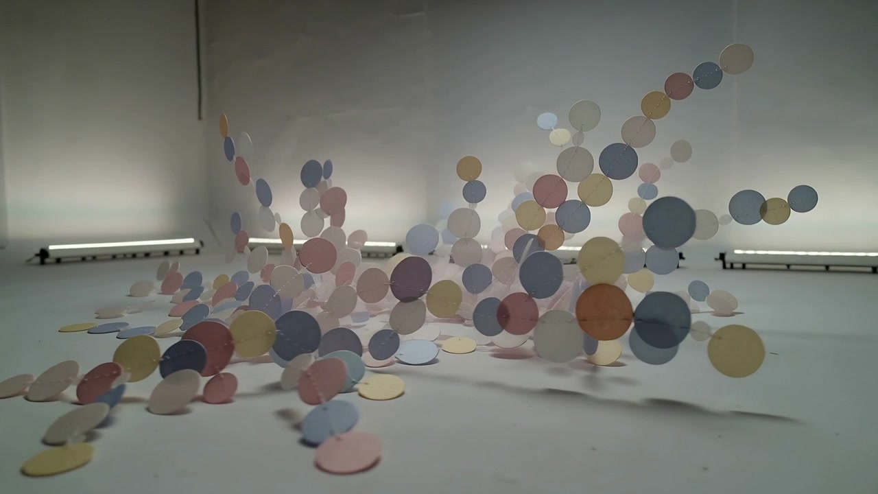 Surging pastel disc installation rising after central impulse across gallery floor, revealing stems