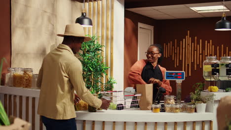 african american seller working at supermarket cash register counter