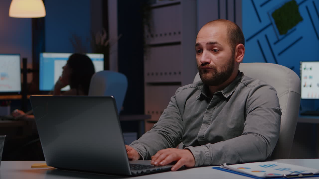 Happy cheerful businessman working in startup company office late at night