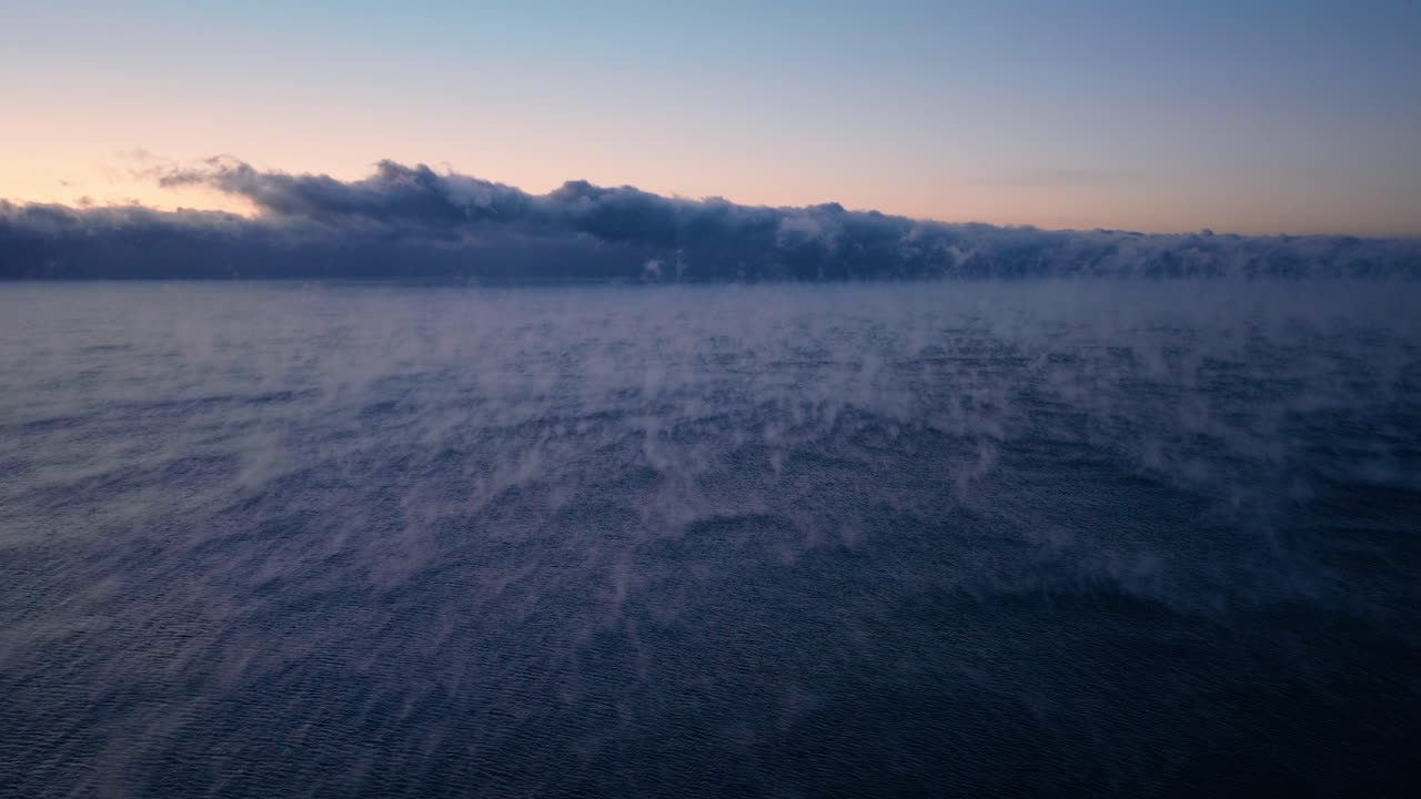 Wide panoramic shot of thick sea smoke covering Lake Superior during a cold winter sunrise