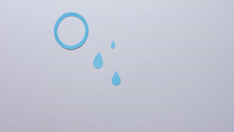 manos de una mujer caucásica sosteniendo un glucometro sobre gotas azules y un círculo en gris, cámara lenta