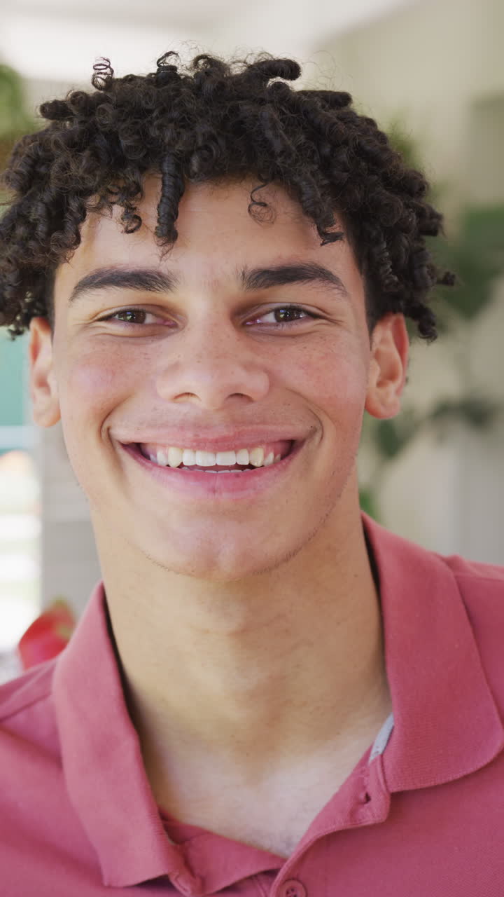 Vertical video of portrait of happy biracial man spending time at home