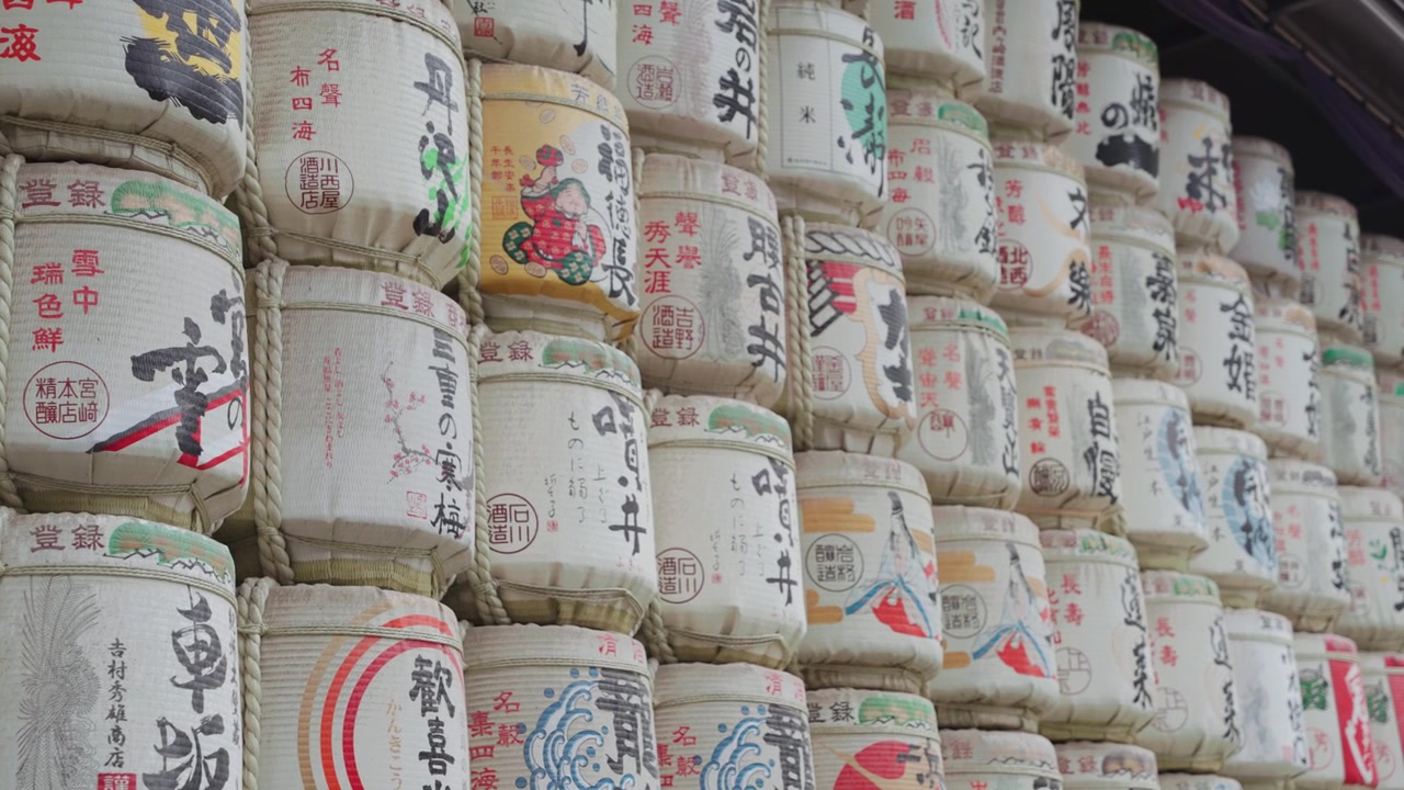 Gerakan panning gerak lambat di sepanjang tong sake yang berwarna-warni dan indah di Kuil Meiji Jingu pada siang hari di Taman Yoyogi, Tokyo