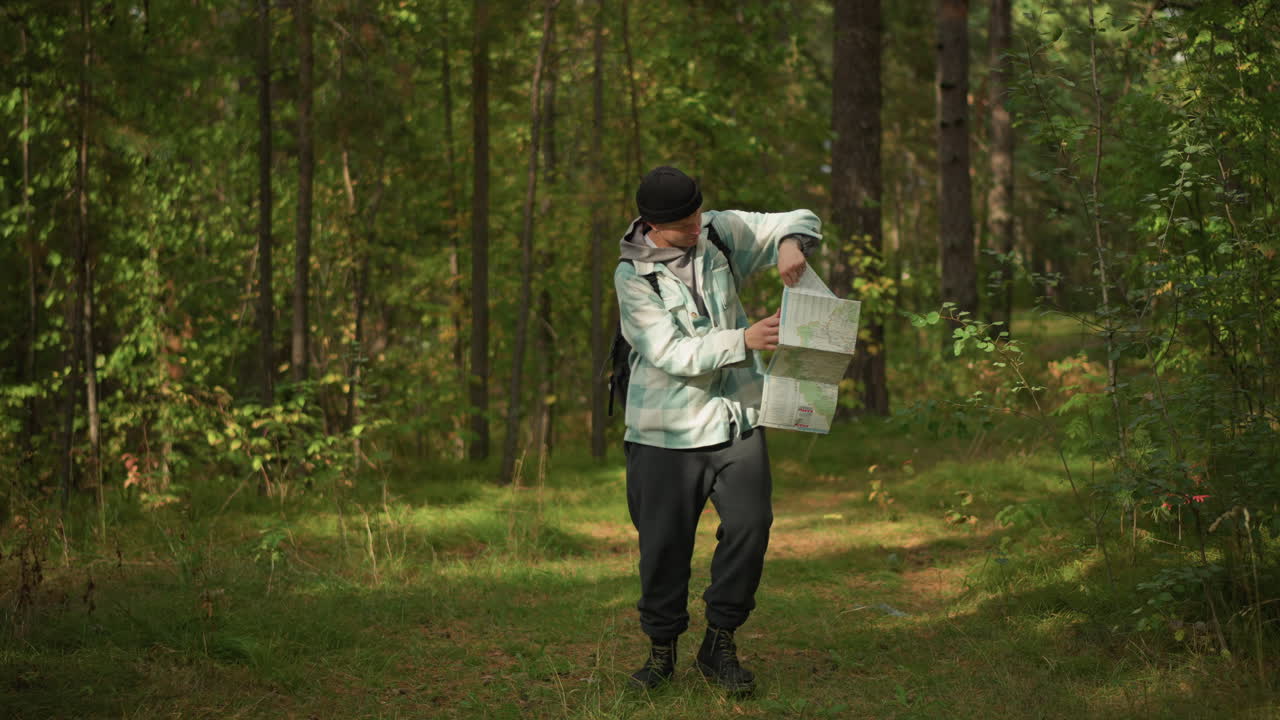 forest path white male hiker consulting map under pine canopy, adjusting backpack, checking watch, pondering route, orienteering vibe with dappled sunlight, focused expression and travel planning
