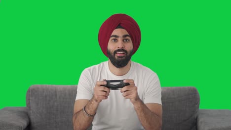 hombre indio sikh serio jugando videojuegos pantalla verde