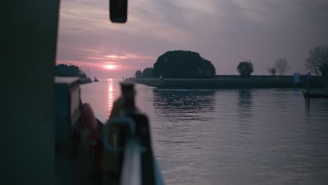 sunset view over calm waters from a boat on burano island, venice