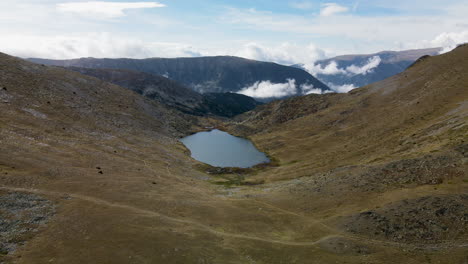 Aproximación-Aérea-A-Un-Pequeño-Lago-En-Medio-De-Un-Valle-En-Las-Montañas-Cerca-De-Puymorens